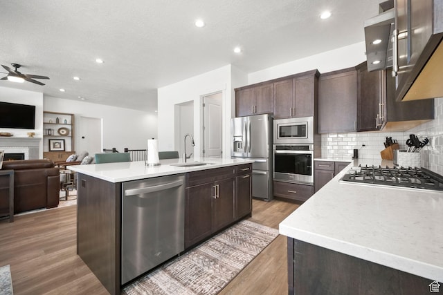 1712 S 1160 E, Heber City, UT 84032 - kitchen with appliances with stainless steel finishes, sink, decorative backsplash, a center island with sink, and light hardwood / wood-style flooring