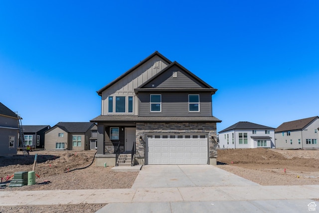 view of front facade with a residential view, driveway, stone siding, board and batten siding, and an attached garage