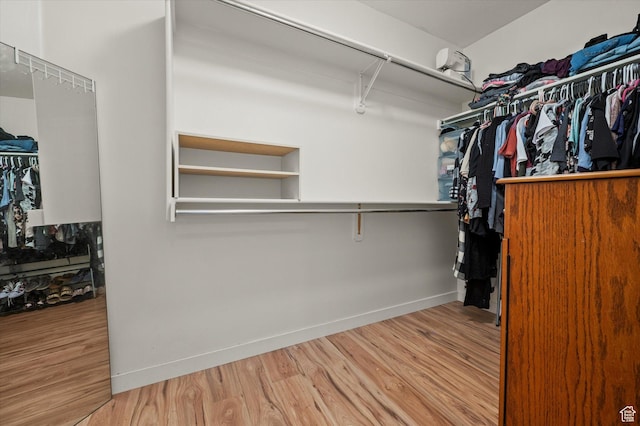 walk in closet with wood finished floors