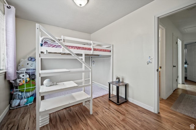 bedroom with wood finished floors and baseboards