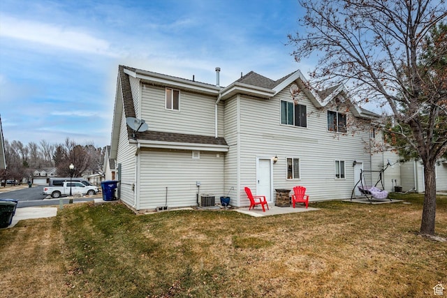 back of house featuring a shingled roof, a lawn, a patio, and central air condition unit