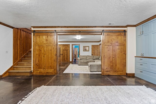 361 N 100 W, Holden, UT 84636 - unfurnished living room with crown molding, a barn door, and a textured ceiling