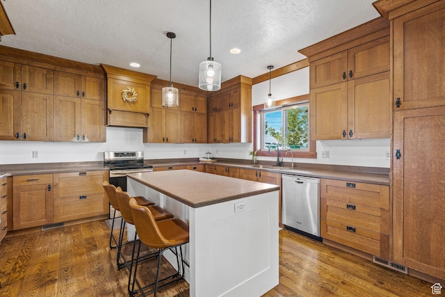 361 N 100 W, Holden, UT 84636 - kitchen with a breakfast bar, stainless steel appliances, dark hardwood / wood-style floors, a center island, and decorative light fixtures
