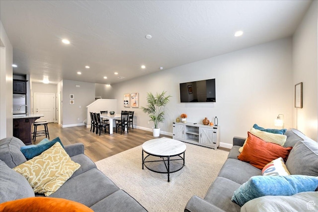 living room featuring sink and light hardwood / wood-style flooring
