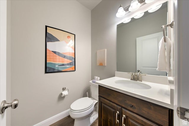 bathroom featuring vanity, hardwood / wood-style flooring, and toilet