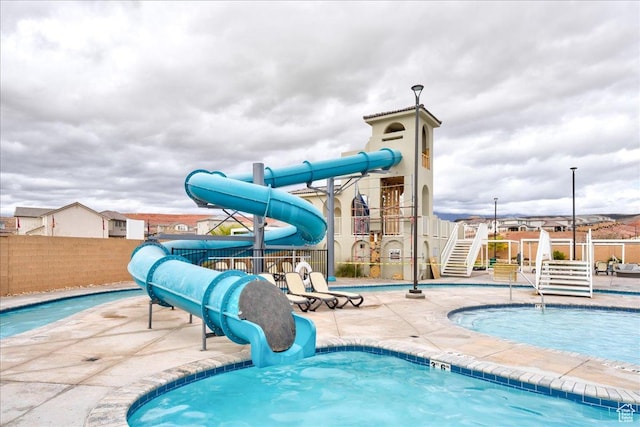 view of pool featuring a water slide and a playground