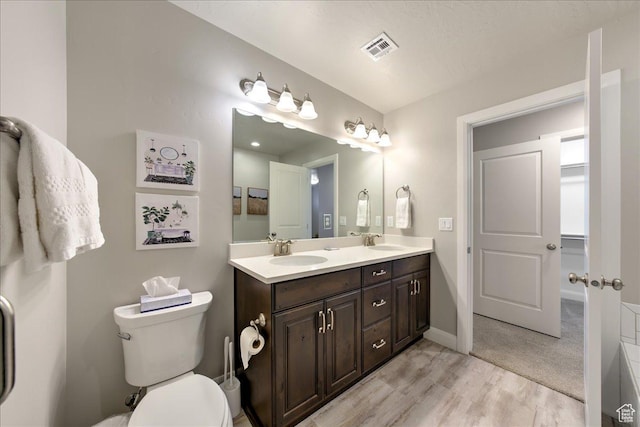bathroom with vanity, hardwood / wood-style flooring, and toilet