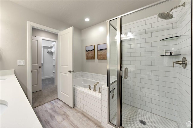 bathroom with independent shower and bath, vanity, and hardwood / wood-style flooring