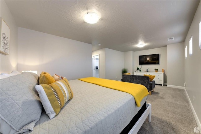 bedroom with light colored carpet and a textured ceiling