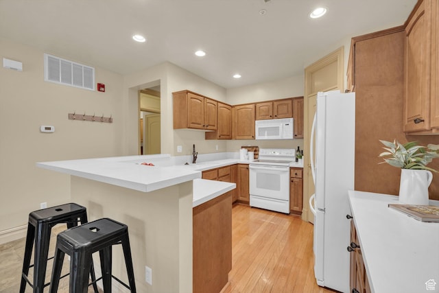 150 S 300 E Unit 202, Salt Lake City, UT 84111 - kitchen featuring sink, white appliances, a kitchen breakfast bar, light hardwood / wood-style floors, and kitchen peninsula