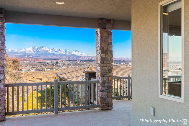 view of patio featuring a balcony and a mountain view