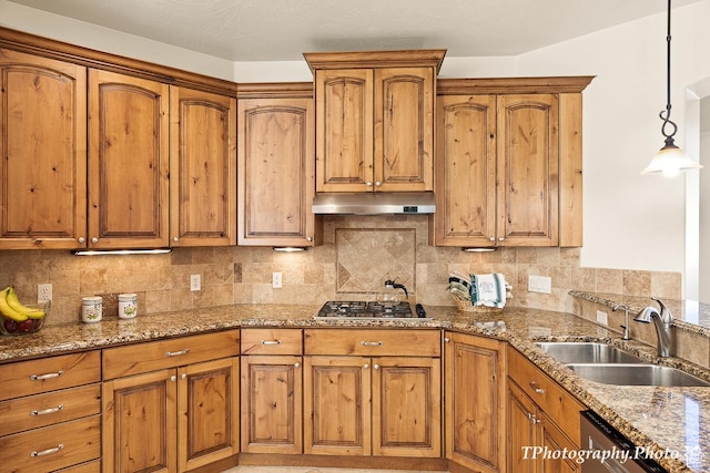 kitchen featuring decorative light fixtures, sink, decorative backsplash, light stone counters, and stainless steel appliances