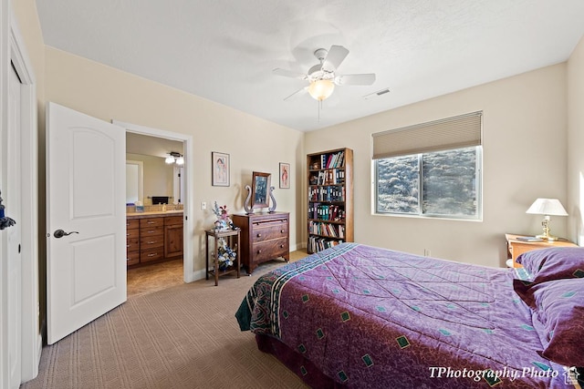 carpeted bedroom with ceiling fan and ensuite bath