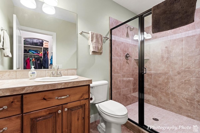bathroom featuring vanity, toilet, and a shower with door