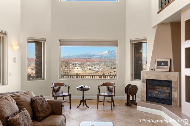 tiled living room with a towering ceiling and a fireplace