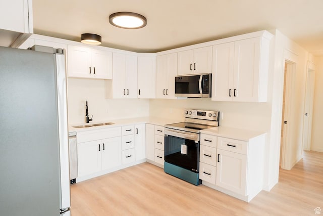 1898 N Rocky Ford Dr, Sigurd, UT 84657 - kitchen featuring appliances with stainless steel finishes, a sink, light wood-style floors, light countertops, and white cabinetry