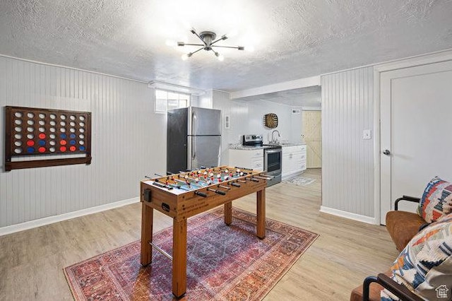 575 N 300 E, Tremonton, UT 84337 - game room with a textured ceiling, light wood finished floors, and baseboards