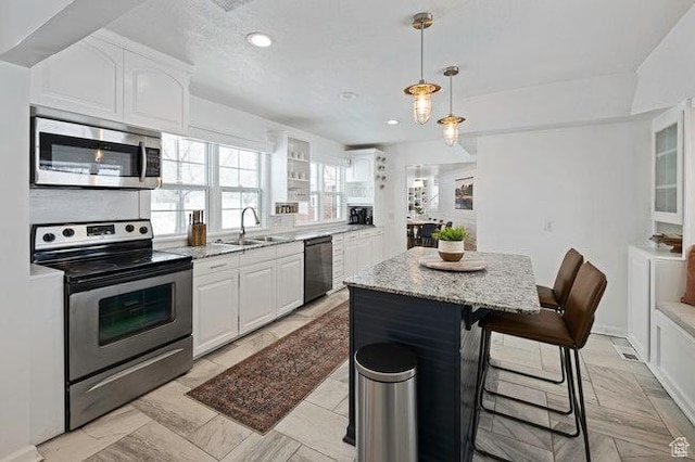 575 N 300 E, Tremonton, UT 84337 - kitchen featuring a sink, a center island, a breakfast bar area, white cabinetry, and appliances with stainless steel finishes