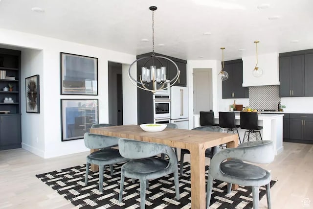 5291 W 3775 S Unit 22, Hooper, UT 84315 - kitchen with decorative light fixtures, a chandelier, light hardwood / wood-style flooring, white appliances, and decorative backsplash