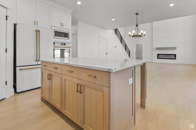 5291 W 3775 S Unit 22, Hooper, UT 84315 - kitchen with pendant lighting, stainless steel appliances, light hardwood / wood-style floors, a kitchen island, and light brown cabinetry