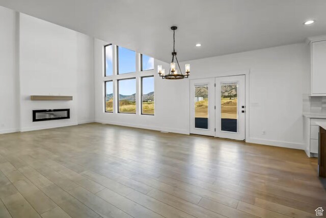 5291 W 3775 S Unit 22, Hooper, UT 84315 - unfurnished living room featuring light hardwood / wood-style floors and a notable chandelier