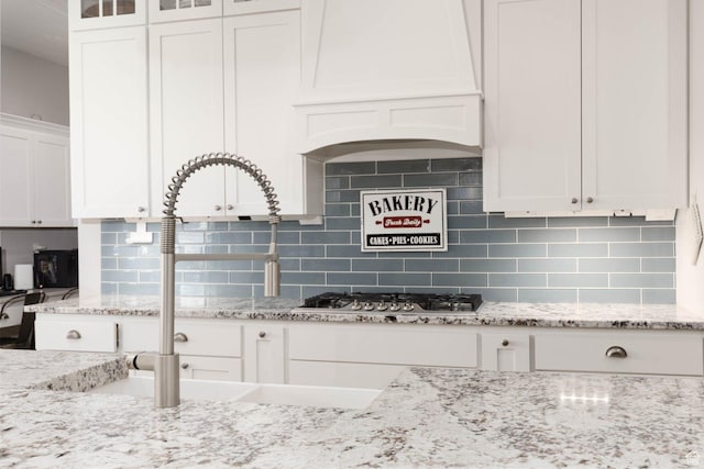 717 S 775 W, Hurricane, UT 84737 - kitchen featuring stainless steel gas cooktop, white cabinets, light stone counters, and decorative backsplash