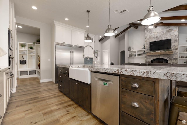 717 S 775 W, Hurricane, UT 84737 - kitchen with dark brown cabinetry, white cabinetry, hanging light fixtures, appliances with stainless steel finishes, and light stone countertops