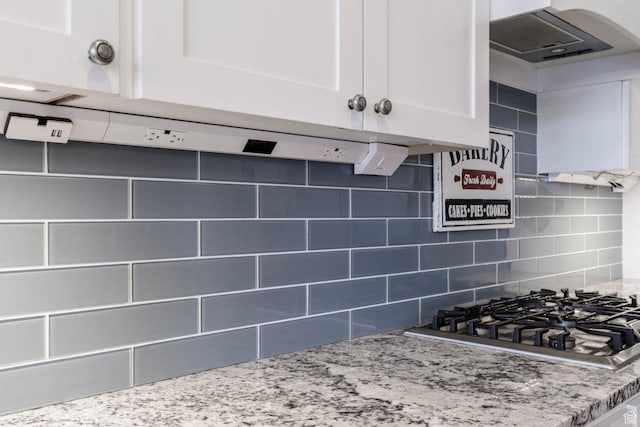 717 S 775 W, Hurricane, UT 84737 - kitchen featuring stainless steel gas cooktop, white cabinetry, light stone countertops, decorative backsplash, and exhaust hood