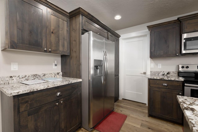 717 S 775 W, Hurricane, UT 84737 - kitchen featuring light stone countertops, appliances with stainless steel finishes, dark brown cabinets, and light wood-type flooring