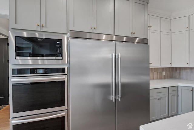 310 S Autumn Blaze Cir, Woodland Hills, UT 84653 - kitchen featuring gray cabinets, backsplash, built in appliances, light stone counters, and light hardwood / wood-style floors