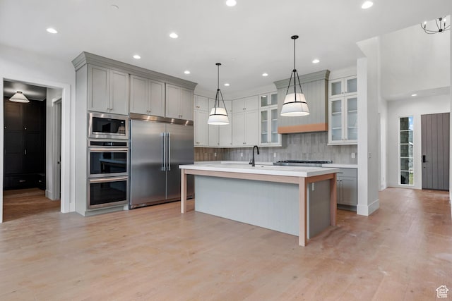 310 S Autumn Blaze Cir, Woodland Hills, UT 84653 - kitchen with built in appliances, hanging light fixtures, gray cabinets, and a center island with sink