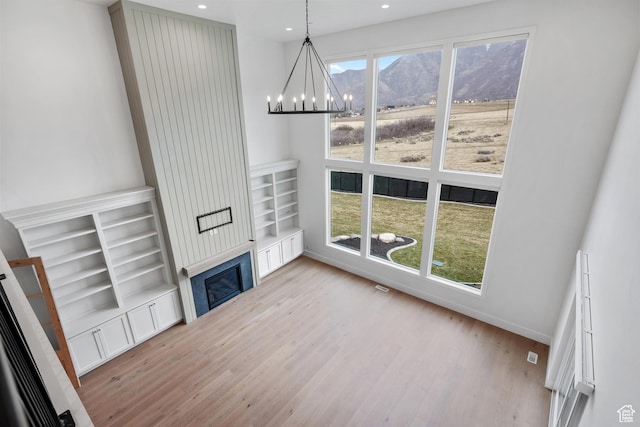 310 S Autumn Blaze Cir, Woodland Hills, UT 84653 - unfurnished living room featuring a mountain view, a large fireplace, a chandelier, and light hardwood / wood-style flooring