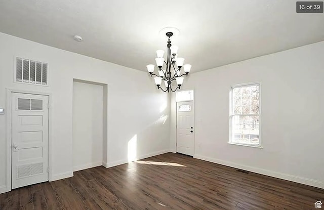 unfurnished dining area featuring dark wood-type flooring and a chandelier