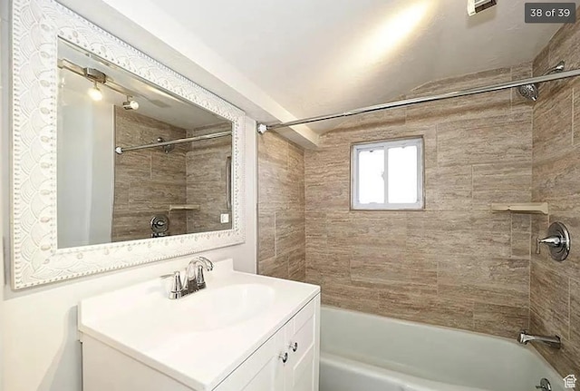 bathroom featuring tiled shower / bath combo and vanity