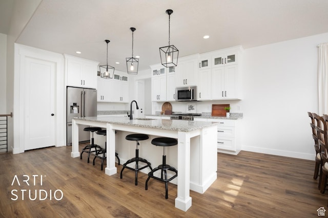 429 W Olympic Ln, Elk Ridge, UT 84651 - kitchen featuring a center island with sink, dark wood finished floors, a breakfast bar area, appliances with stainless steel finishes, and a sink