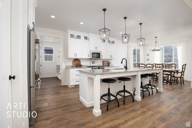 429 W Olympic Ln, Elk Ridge, UT 84651 - kitchen featuring white cabinets, a breakfast bar area, dark wood-style flooring, stainless steel appliances, and a sink
