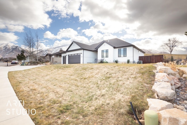 429 W Olympic Ln, Elk Ridge, UT 84651 - view of front of house featuring an attached garage, fence, a mountain view, and a front yard