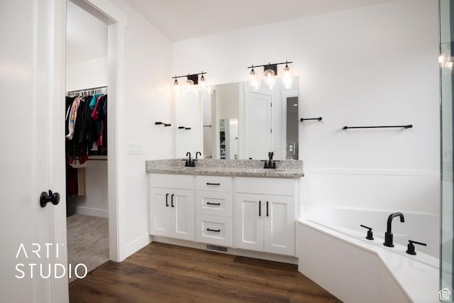 429 W Olympic Ln, Elk Ridge, UT 84651 - bathroom with a sink, wood finished floors, a bath, double vanity, and a walk in closet