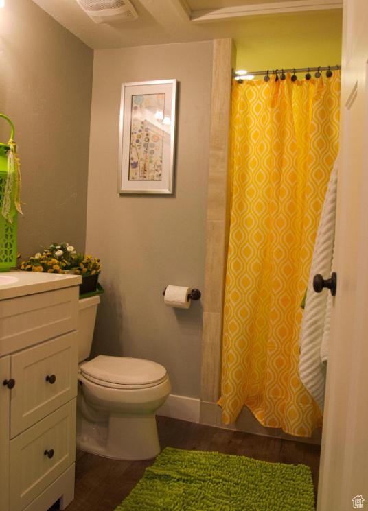 bathroom with vanity, hardwood / wood-style flooring, toilet, and walk in shower