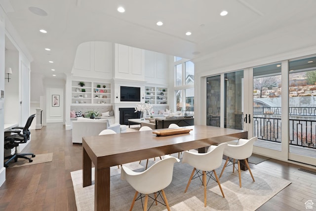 dining room with built in shelves and hardwood / wood-style floors