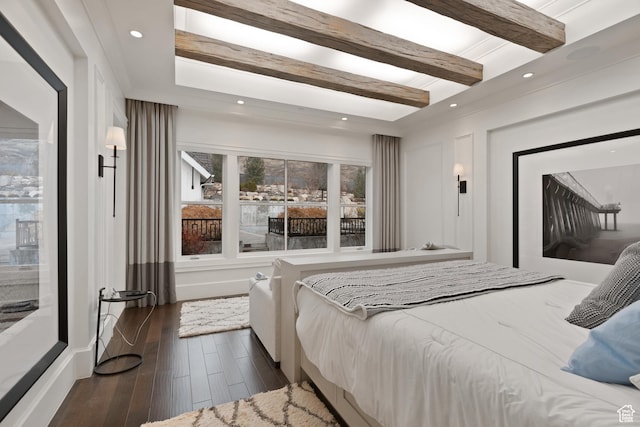 bedroom with beamed ceiling and dark hardwood / wood-style flooring