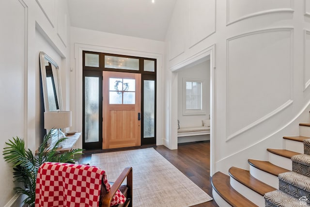 entryway featuring dark wood-type flooring and vaulted ceiling