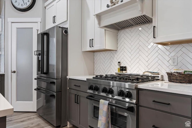 7160 S 1100 E, South Weber, UT 84405 - kitchen featuring white cabinetry, backsplash, premium appliances, custom exhaust hood, and light wood-type flooring