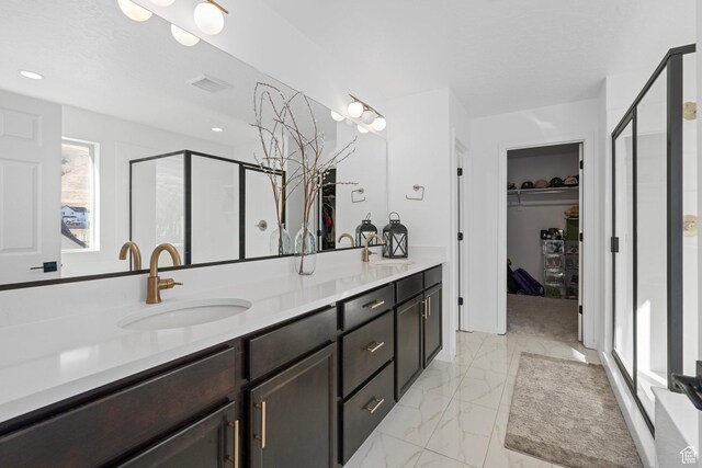 bathroom with vanity, a textured ceiling, and a shower with shower door