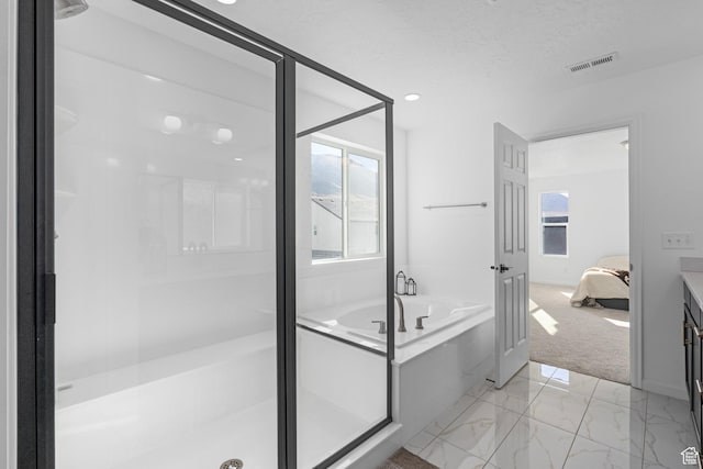 bathroom with vanity, shower with separate bathtub, and a textured ceiling