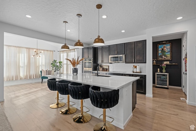 kitchen with hanging light fixtures, sink, and a center island with sink