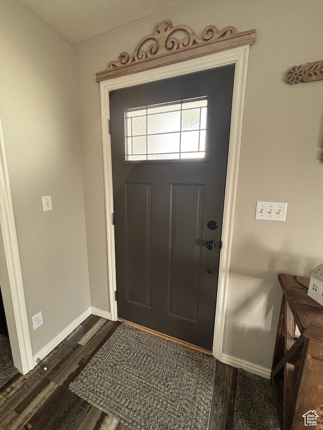 foyer featuring dark wood-style floors and baseboards