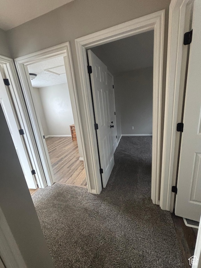corridor featuring carpet floors and baseboards