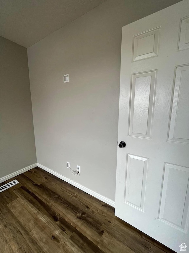 empty room with baseboards and dark wood finished floors