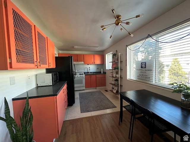 2220 E Murray Holladay Rd Unit 140, Holladay, UT 84117 - kitchen featuring white gas range, dark countertops, freestanding refrigerator, and under cabinet range hood